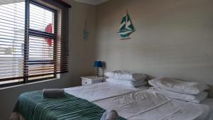 a bedroom with a large bed and a window at Nautica Strand in Cape Town
