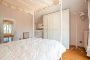 um quarto com uma cama de dossel branca em La Gipsofila Attic em Osimo