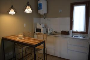 a kitchen with a table and chairs and a microwave at Inti. in Saladillo