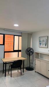 Habitación con mesa, silla y ventilador en Moderno Apartaestudio, Central MDE - 503, en Medellín