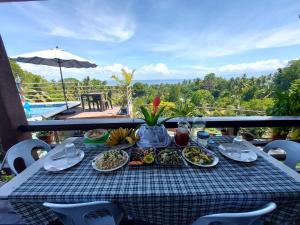 a table with plates of food on top of a balcony at Island samal overlooking view house with swimming pools in San Antonio