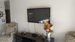 a living room with a tv and a vase of flowers at Nautica Strand in Cape Town