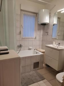 a bathroom with a tub and a toilet and a sink at Apartment Sky in Solin