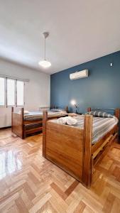 Habitación con 2 camas, paredes azules y suelo de madera. en Villa en Mendoza, Argentine en Luján de Cuyo