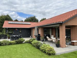 ein Haus mit einer Terrasse mit einem Tisch und Stühlen in der Unterkunft Casa Jakobsen in Randers