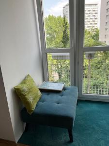 a blue couch with a laptop on it in front of a window at Apartament Powiśle in Warsaw