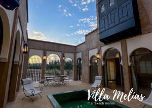 a patio with a table and chairs and a pool at Villa Melias in Marrakesh