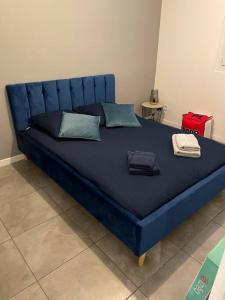a blue bed with two pillows on top of it at Ô Calme ! Logement Rénové à Neuf - Une Expérience Unique - Wifi Gratuit in Grenoble
