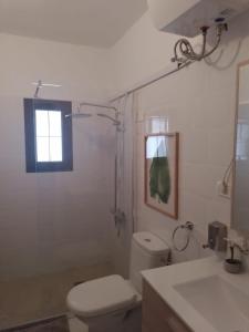a bathroom with a toilet and a sink and a window at Hotel Masai Mara Resort Gran Canaria in San Bartolomé de Tirajana