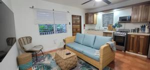 a living room with a blue couch in a kitchen at Alux House in Placencia Village