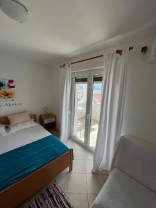 1 dormitorio con cama, ventana y sofá en Apartments Edina, en Pag