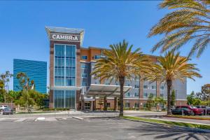 a hotel with palm trees in a parking lot at Cambria Hotel LAX in El Segundo