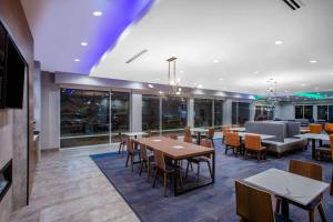 a dining area with tables and chairs in a building at La Quinta Inn & Suites by Wyndham Oxford in Oxford