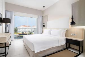 um quarto com uma grande cama branca e uma grande janela em Radisson Blu Residences, Saidia em Saïdia