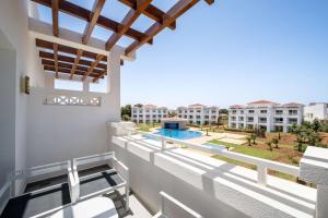 a balcony with a view of the pool and buildings at Radisson Blu Residences, Saidia in Saïdia