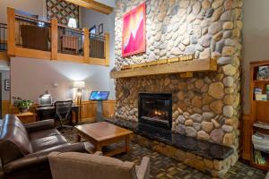 ein Wohnzimmer mit einem großen Steinkamin in der Unterkunft Black Beach Inn by GrandStay in Silver Bay
