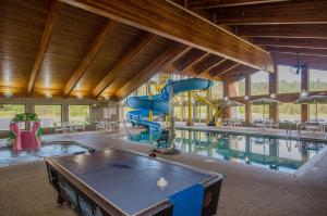 a indoor pool with a slide and a pool table at Black Beach Inn by GrandStay in Silver Bay