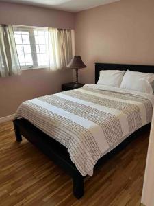 ein Schlafzimmer mit einem großen Bett mit einer weißen Bettdecke in der Unterkunft Cozy Capitol Hill Bungalow - 3BD/2BA Retreat in Burnaby