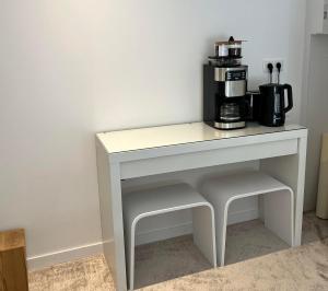 un tavolo bianco con una macchinetta del caffè sopra di Domaine de Mende Brenoux Suites & SPA a Mende