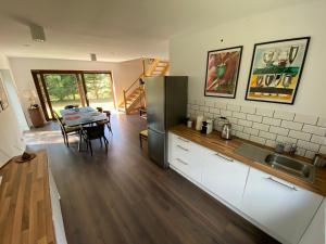 a kitchen and dining room with a table and refrigerator at Mazurskie Energie dom ekologiczny całoroczny in Stare Juchy