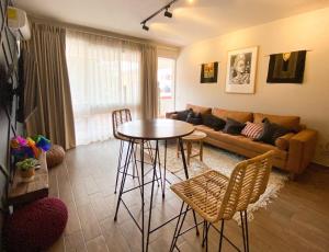 a living room with a table and a couch at Layoo, Tu casa en Oaxaca 101 in Oaxaca City