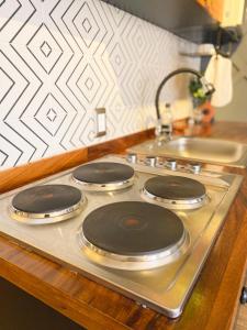 a stove top with three burners on top of it at Layoo, Tu casa en Oaxaca 101 in Oaxaca City +10 photos