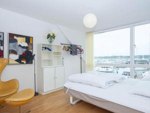een witte slaapkamer met een bed en een raam bij Holiday home Grenaa XLIX in Grenå