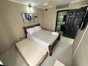 a small bedroom with a bed and a door at Hermoso Apartamento con Piscina 1 Habitacion PR32 in Montería
