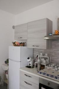 a kitchen with white cabinets and a white refrigerator at B&b la Casa dei Nonni in Silvi Paese