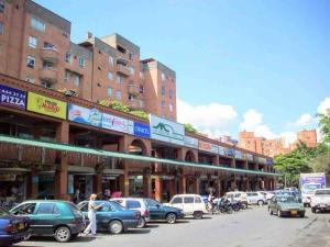una calle de la ciudad con coches estacionados frente a los edificios en Stefi house en Belén la mota Wifi en Medellín