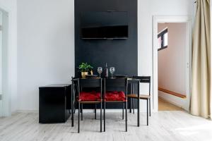 a dining room with a black table with red chairs at CityHeart Studio in Bucharest
