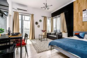 a bedroom with a bed and a living room at CityHeart Studio in Bucharest