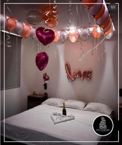 ein Schlafzimmer mit Ballons und einem Bett mit einer Flasche Champagner in der Unterkunft Sky Towers in Cúcuta