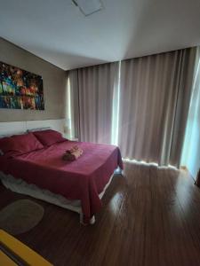 a bedroom with a bed with a purple bedspread at Apto ótima localização, self check-in, wi-fi, varanda e vista linda - 401 in Lagoa Santa