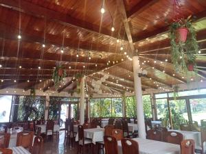 une salle à manger avec des tables, des chaises et des lumières dans l'établissement Hotel el sol de los incas, à Los Baños del Inca