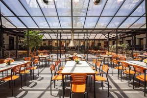 a restaurant with tables and chairs and a glass ceiling at San Jose de Puembo Quito Airport, an Ascend Collection Hotel in Puembo