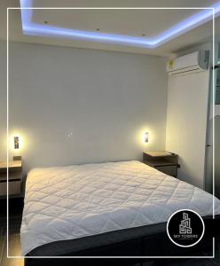 ein Schlafzimmer mit einem weißen Bett mit blauem Licht in der Unterkunft Sky Towers in Cúcuta