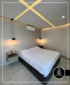 a bedroom with a large white bed and a table at Sky Towers in Cúcuta
