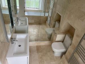 La salle de bains est pourvue d'un lavabo et de toilettes. dans l'établissement Kensington Luxury Apartments, à Londres