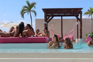 um grupo de pessoas na água em uma piscina em Hotel The Palm em Playa del Carmen