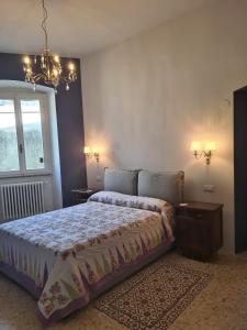 a bedroom with a bed and a chandelier at Corte Averaldo in San Felice del Benaco