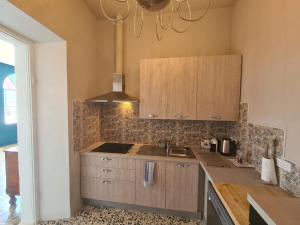 a kitchen with wooden cabinets and a sink and a chandelier at Corte Averaldo in San Felice del Benaco