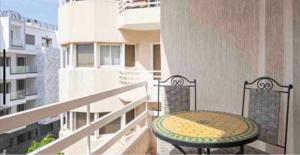 a balcony with a table on the side of a building at APARTMENT HAY RYAD 200 M2 STANDIG in Rabat