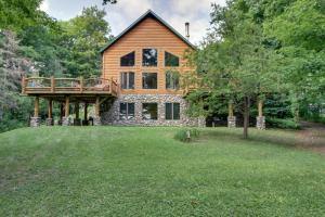 a house with a deck on top of a yard at Pokegama Lake Vacation Rental with Shared Boat Dock! in Grand Rapids