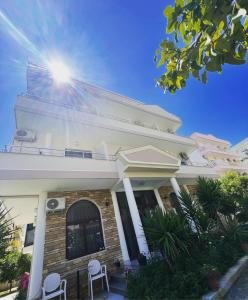 una casa blanca con dos sillas blancas delante en Red Rose Guest House, en Golem