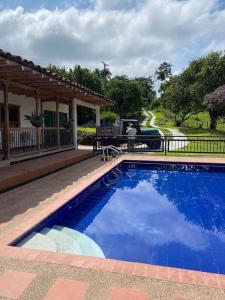 a large blue swimming pool in front of a house at Alojamiento Rural - La Perla in Filandia