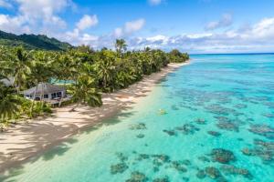 an island in the ocean with palm trees and a beach at Sands Villas in Rarotonga