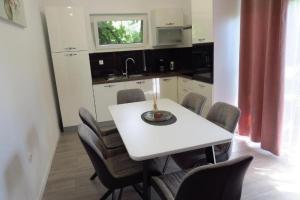 a kitchen with a white table and some chairs at Apartments with a parking space Sinj, Zagora - 21628 in Sinj +6 photos