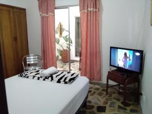 um quarto de hotel com uma cama e uma televisão em CERCA AL AEROPUERTO CONTRALORIA AL LADO HOTEL TORREON No ES DOS QUEBRADAS MEDIA CUADRA ESTACION UCUMARI 30 AGOSTO em Pereira