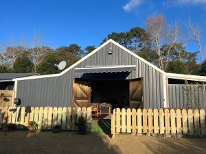 a barn with a fence in front of it at Waiora la grange cottage in Otaki